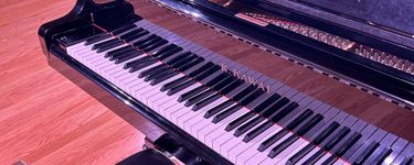 a K. Kawai grand piano keyboard focused on the stage at PCM